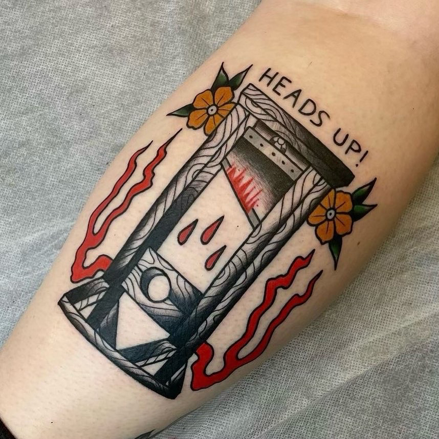 Image of a new tattoo on a mans arm. The style of the tattoo blends realism style with an artistic flair. It is black and grey and also red colour.